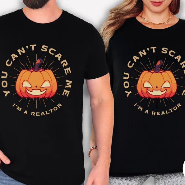Two people wearing black t-shirts with a Halloween-themed design and text.