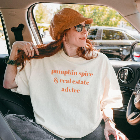 Woman sitting in a car wearing a white sweatshirt with text, sitting in a car.