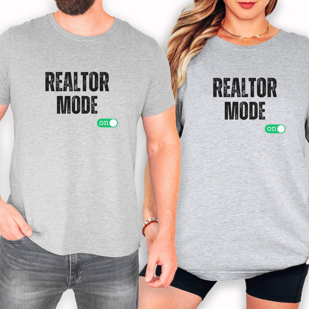 a man and a woman wearing matching gray t-shirts with the text "REALTOR MODE" printed on them.
