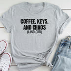 A gray t-shirt with the text "COFFEE, KEYS, AND CHAOS (LANDLORD)" printed on it, along with a pair of jeans and white sneakers.