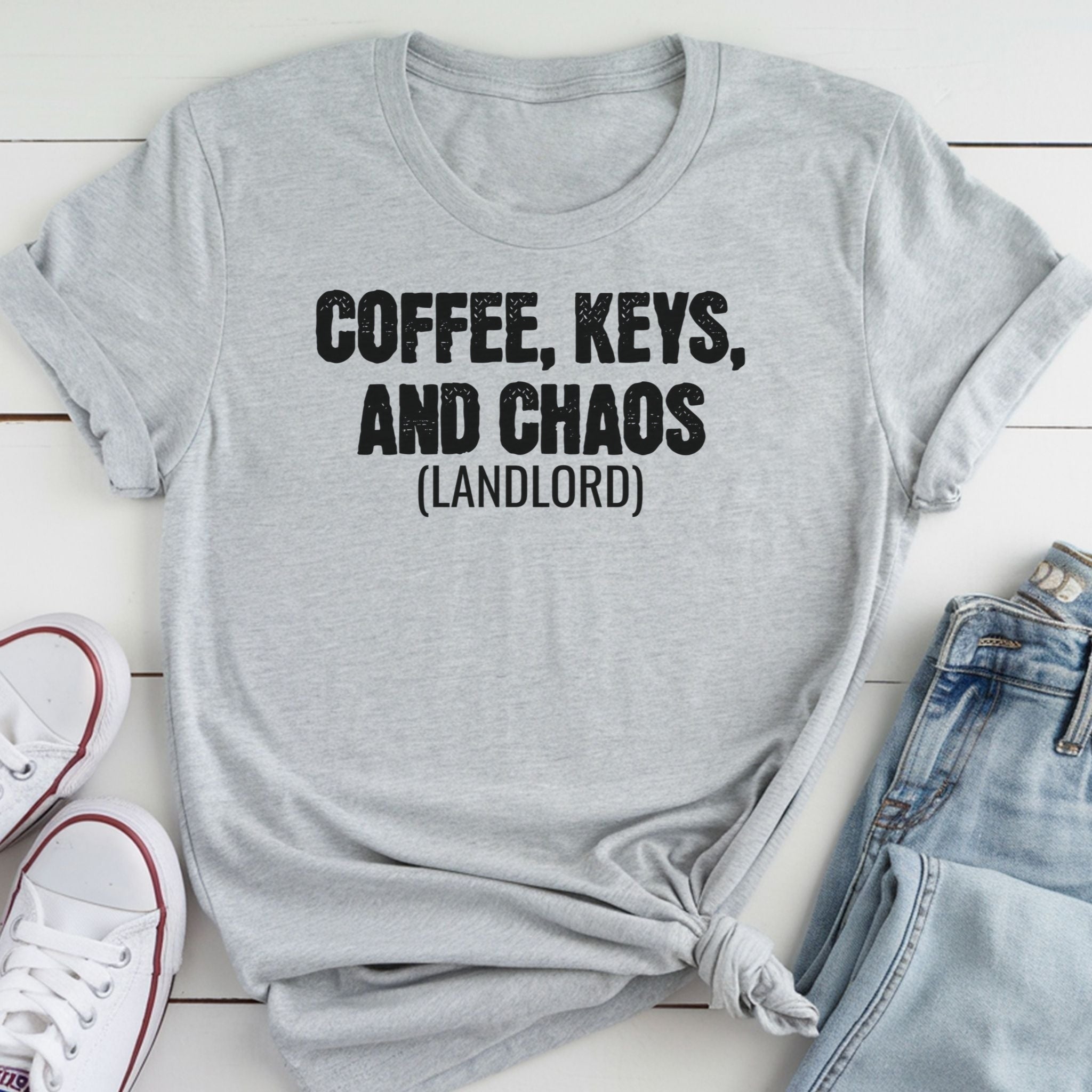 A gray t-shirt with the text "COFFEE, KEYS, AND CHAOS (LANDLORD)" printed on it, along with a pair of jeans and white sneakers.
