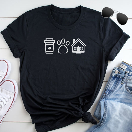 A black t-shirt with white icons of a coffee cup, paw print, and house, along with a pair of jeans and sunglasses, all laid out on a white surface.