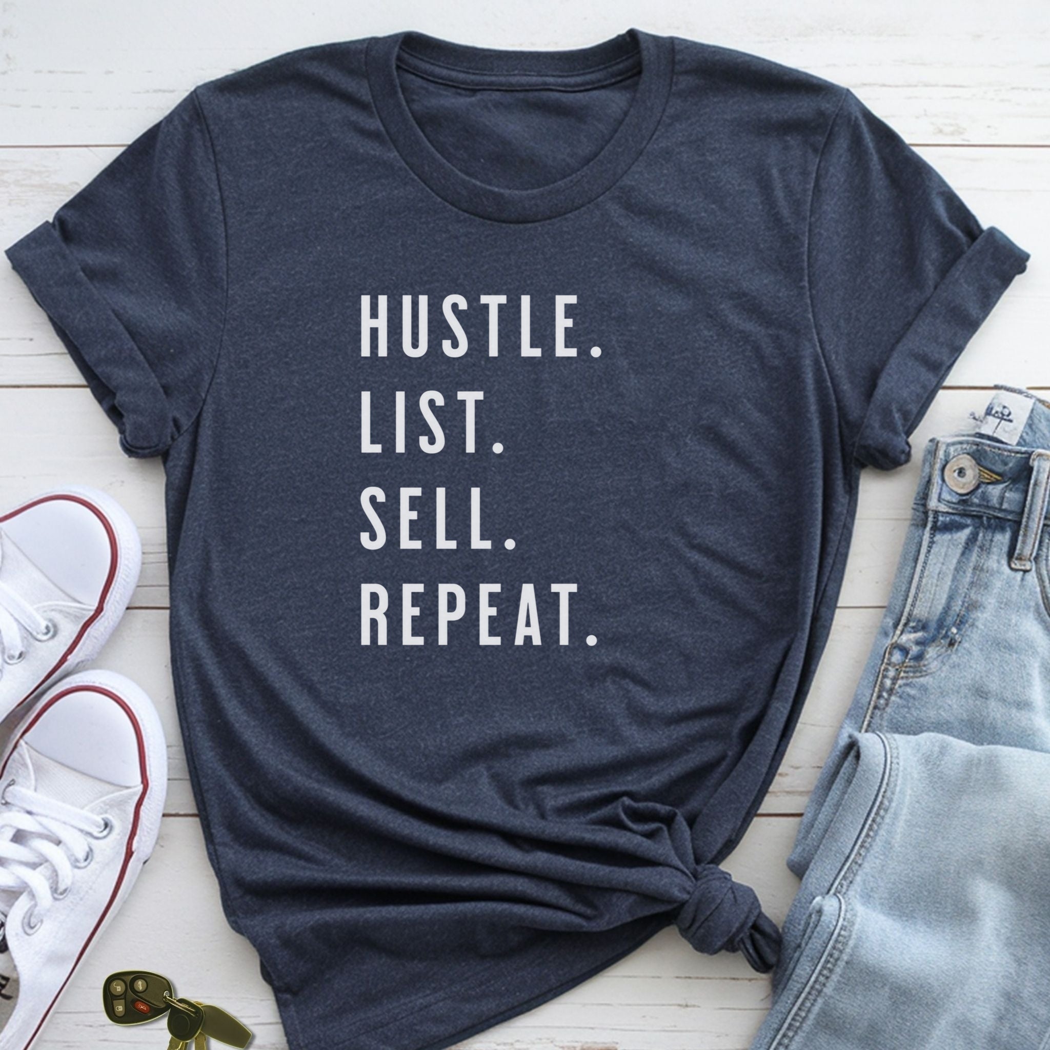 A navy blue t-shirt with the text "HUSTLE. LIST. SELL. REPEAT." printed on it, along with a pair of jeans and white sneakers.