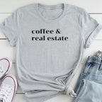 A gray t-shirt with the text "coffee & real estate" printed on it, along with a pair of jeans and white sneakers.