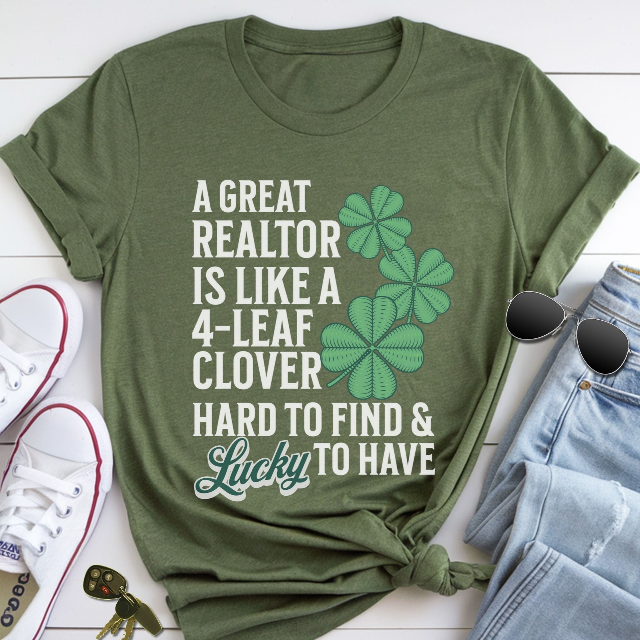 A green t-shirt with a humorous text and clover design, along with a pair of jeans, sunglasses, and a keychain.