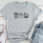 A gray t-shirt with a graphic design of a coffee cup, paw print, and house, along with a pair of jeans and white sneakers.