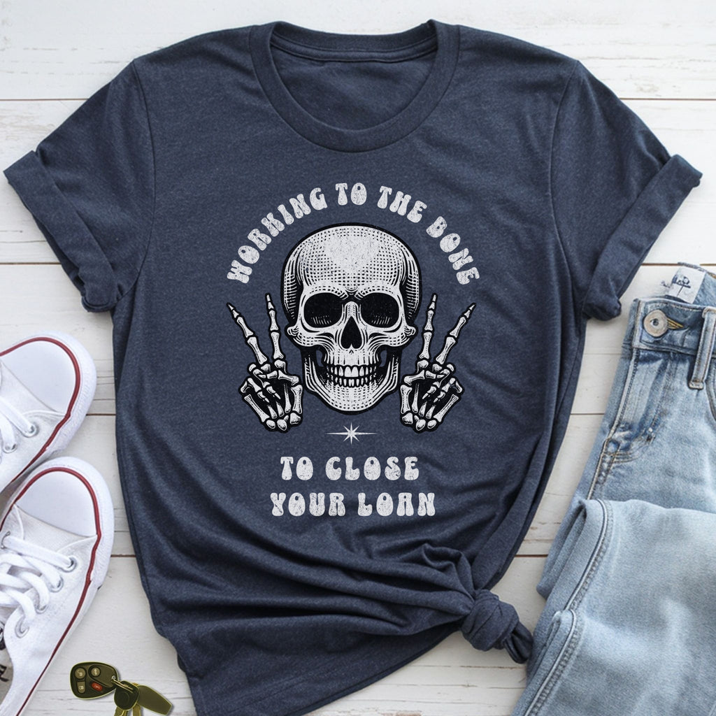 A dark blue t-shirt with a skull graphic and text, along with a pair of jeans and sneakers, laid out on a white surface.