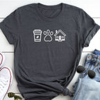 A gray t-shirt with white icons of a coffee cup, paw print, and house, along with a pair of jeans and sunglasses, all laid out on a white surface.