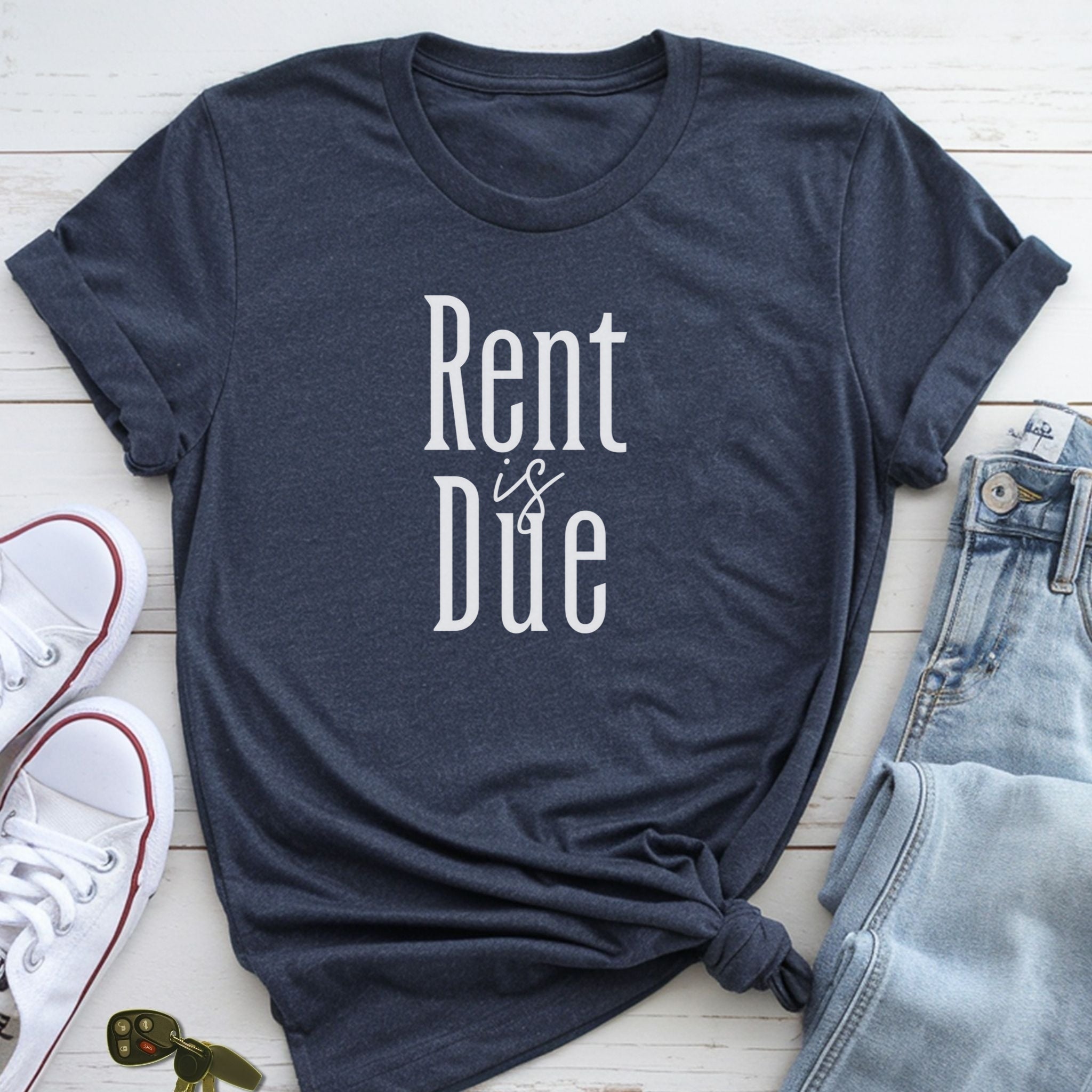 A dark blue t-shirt with the text "Rent is Due" printed on it, along with a pair of jeans and white sneakers.