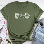 A green t-shirt with white icons of a coffee cup, a paw print, and a house, along with a pair of jeans, sunglasses, and a pair of white sneakers.