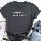 A gray t-shirt with the text "coffee & real estate" printed on it, along with a pair of jeans and sunglasses, all laid out on a white surface.
