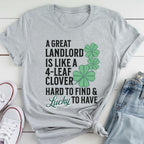 A gray t-shirt with a humorous text and cloverleaf design printed on it, along with a pair of jeans and white sneakers.