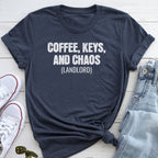 A navy blue t-shirt with the text "COFFEE, KEYS, AND CHAOS (LANDLORD)" printed on it, along with a pair of jeans and white sneakers.