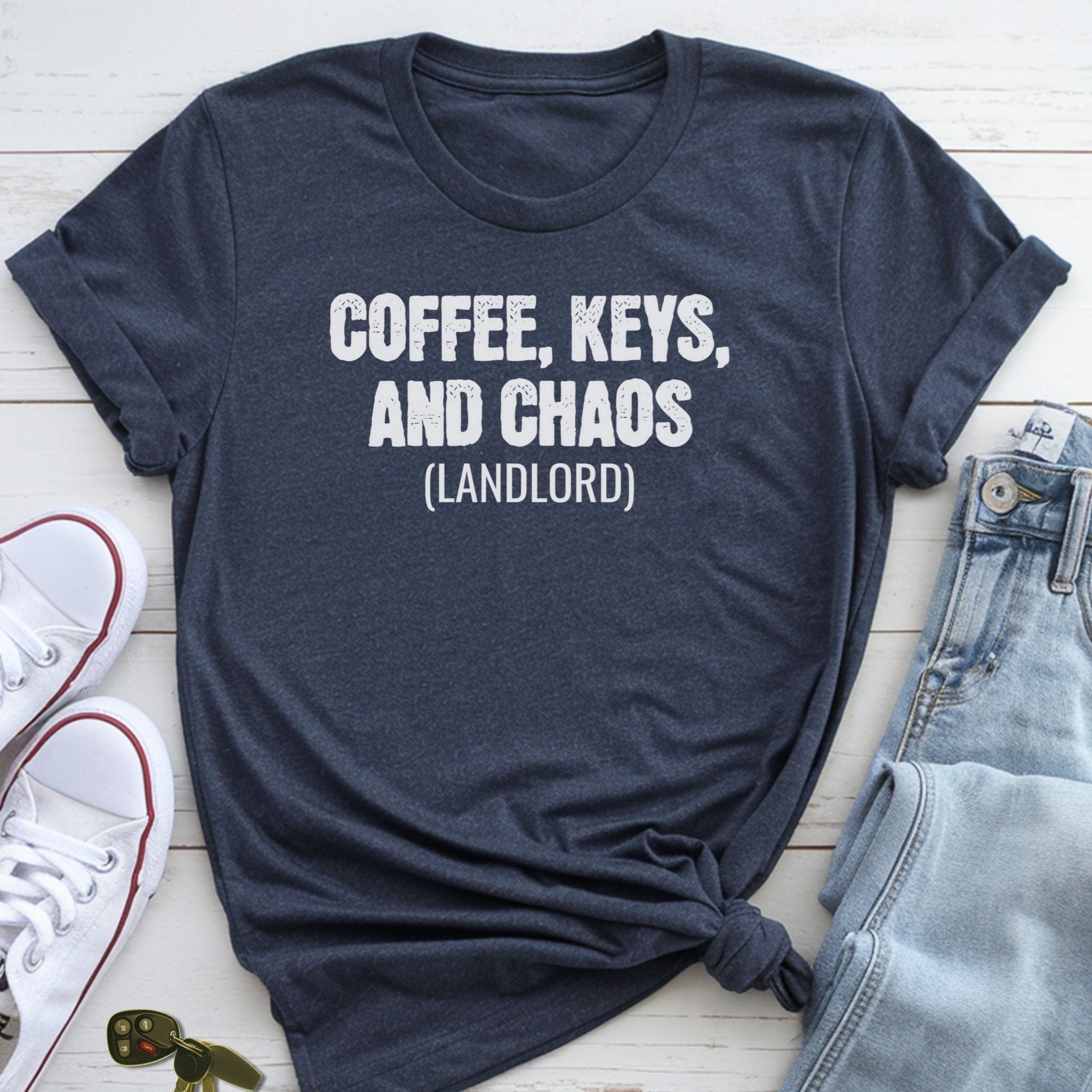 A navy blue t-shirt with the text "COFFEE, KEYS, AND CHAOS (LANDLORD)" printed on it, along with a pair of jeans and white sneakers.