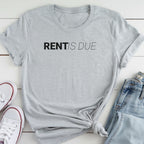 A gray t-shirt with the text "RENT IS DUE" printed on it, along with a pair of jeans and white sneakers.