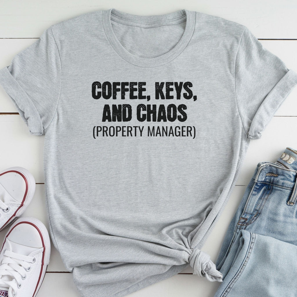 A gray t-shirt with the text "COFFEE, KEYS, AND CHAOS (PROPERTY MANAGER)" printed on it, along with a pair of jeans and white sneakers.
