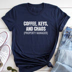 A navy blue t-shirt with the text "COFFEE, KEYS, AND CHAOS (PROPERTY MANAGER)" printed on it, along with a pair of jeans and white sneakers.