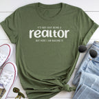 a green t-shirt with a humorous text printed on it, along with a pair of jeans, sunglasses, and a pair of white sneakers.