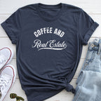 A navy blue t-shirt with the text "COFFEE AND REAL ESTATE" printed on it, along with a pair of jeans and white sneakers.