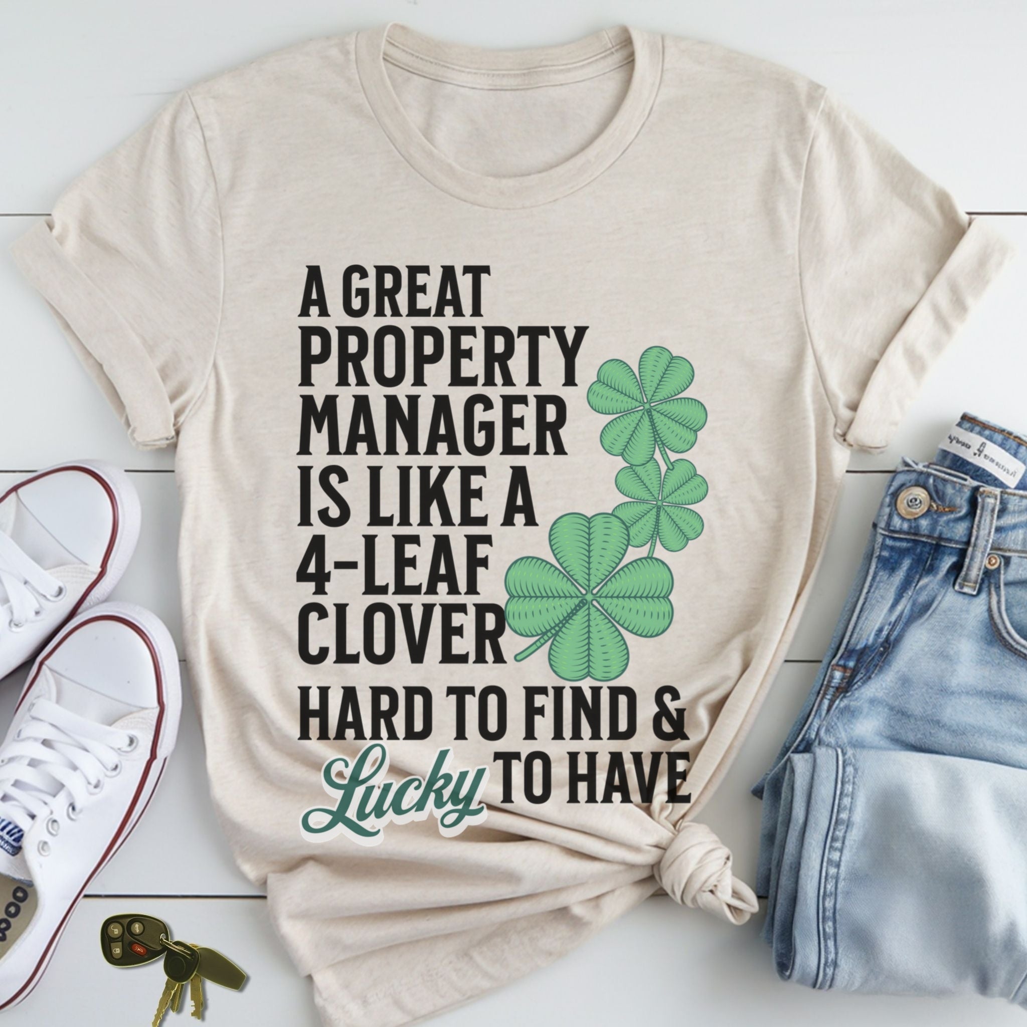 A t-shirt with a humorous text printed on it, along with a pair of jeans and sneakers, all laid out on a white surface.