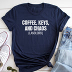 A navy blue t-shirt with the text "COFFEE, KEYS, AND CHAOS (LANDLORD)" printed on it, along with a pair of jeans and a pair of white sneakers.