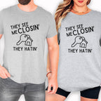 two people wearing gray t-shirts with the same text printed on them.