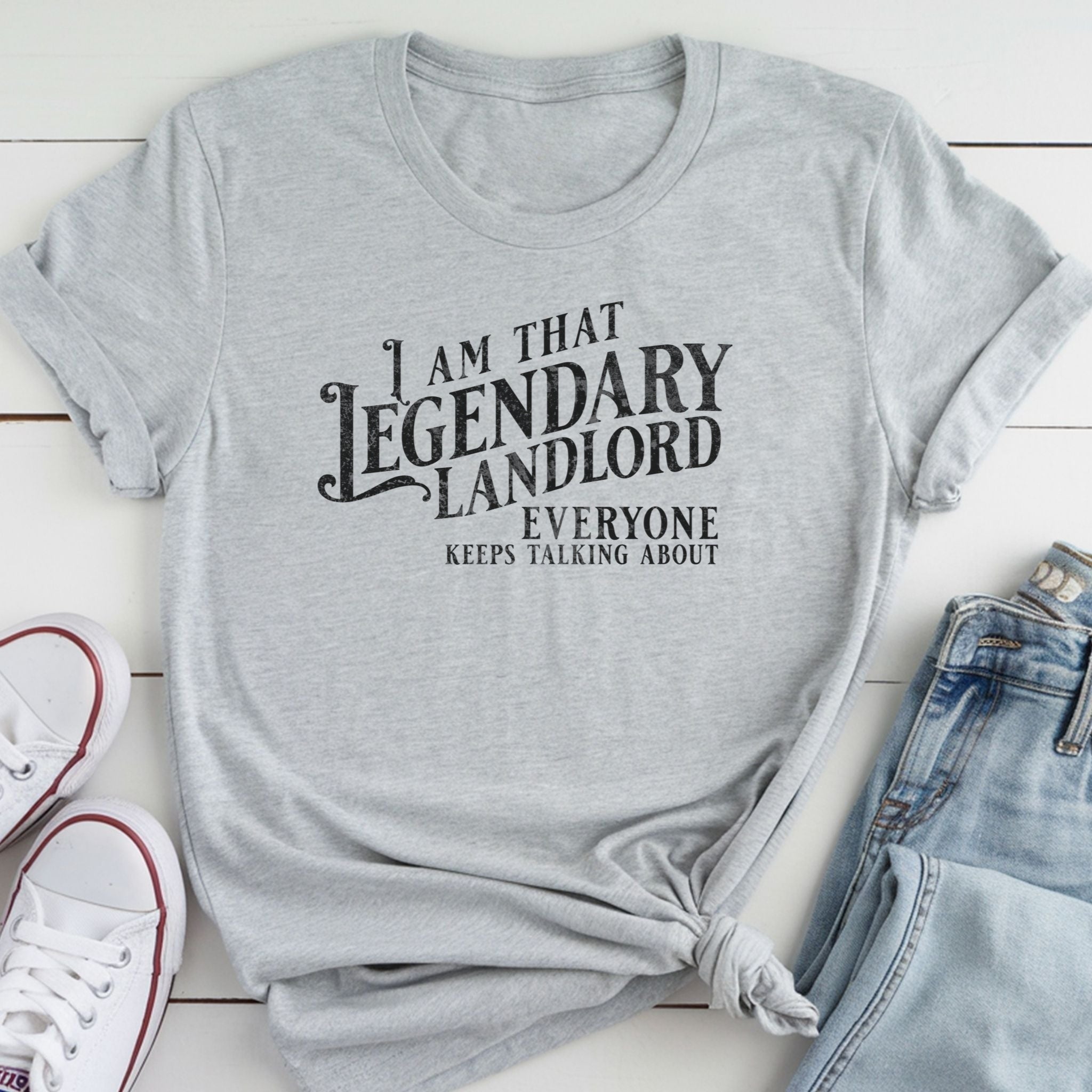 A gray t-shirt with a humorous text printed on it, along with a pair of jeans and white sneakers.