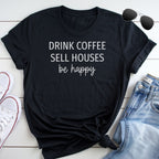 A black t-shirt with the text "DRINK COFFEE SELL HOUSES be happy" printed on it, along with a pair of sunglasses and a pair of jeans.