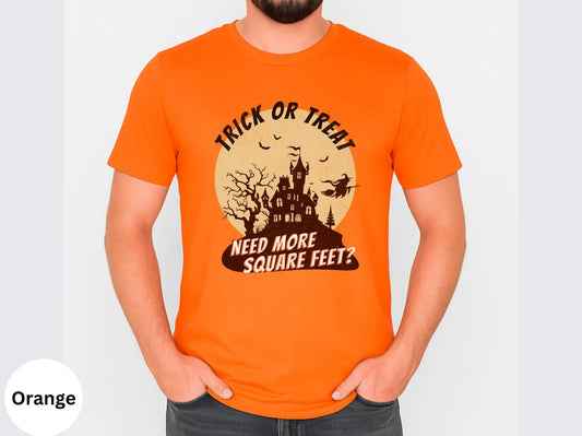 Orange t-shirt with Halloween-themed design featuring a castle and text, worn by a realtor