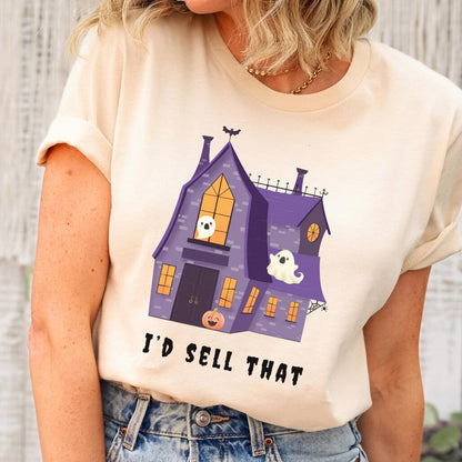 Person wearing a t-shirt with a haunted house graphic and text, standing against a wooden wall.