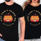 Two people wearing black t-shirts with a Halloween-themed design and text.