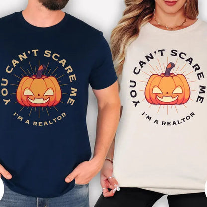 Two people wearing t-shirts with a pumpkin graphic and text, one navy and one natural.