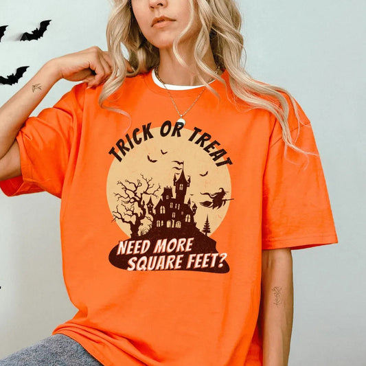 Person wearing an orange Halloween-themed t-shirt with a castle graphic and text.